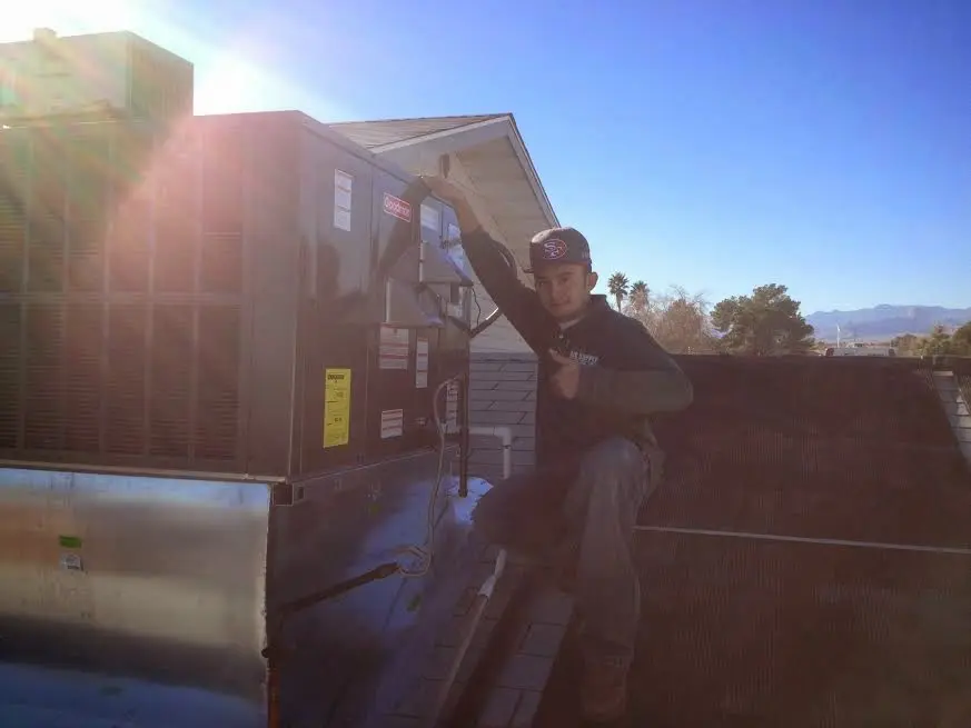 HVAC technician performing AC Tune-Up on a rooftop unit in Halawa